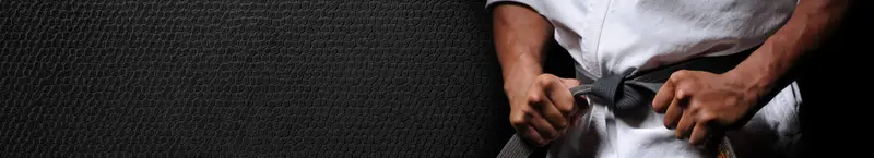 Karateka tying black belt